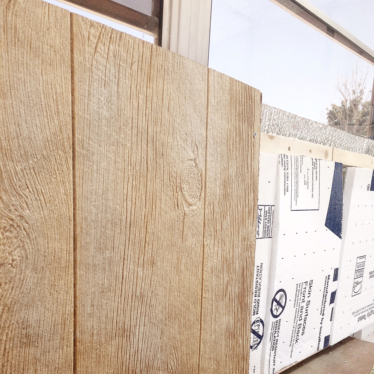 Wood "ribs", rigid foam insulation, and faux barn wood panels going up on the side walls.