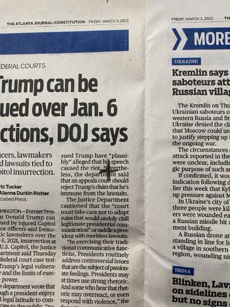 a piece of newspaper with a cross marked on it where the hanging nail will go