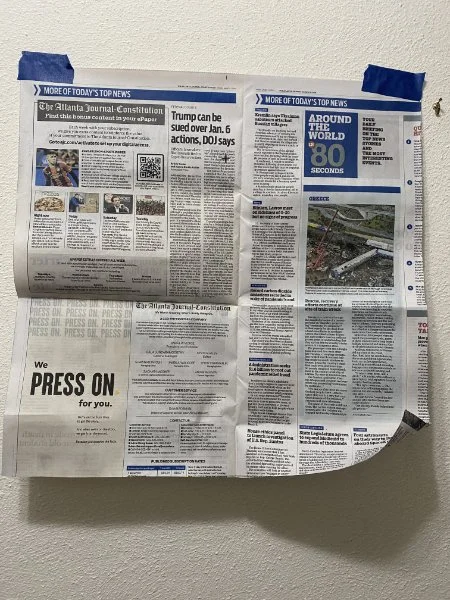 a piece of newspaper taped to a wall