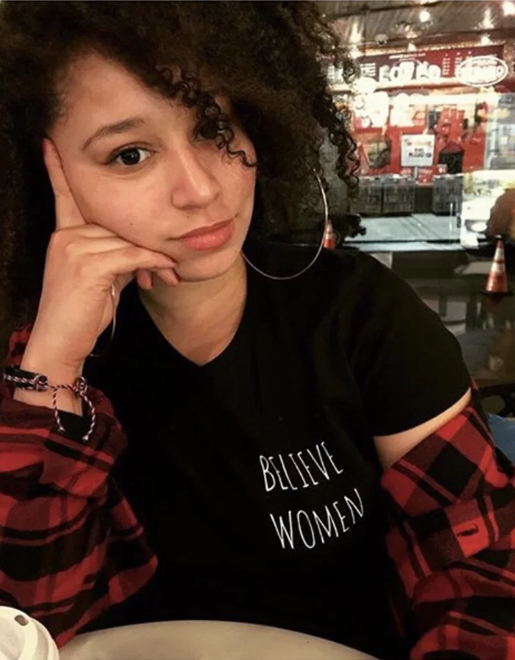 Autumn Myers ( @itsautumnm ), the team’s media correspondent and lead writer, is a Black-American and Puerto Rican cis-gender woman. She is culturally proud of my Black lineage and currently on a journey to discover her Boricua ancestry as well. Autumn wears a short sleeve Black “Believe Women” shirt .