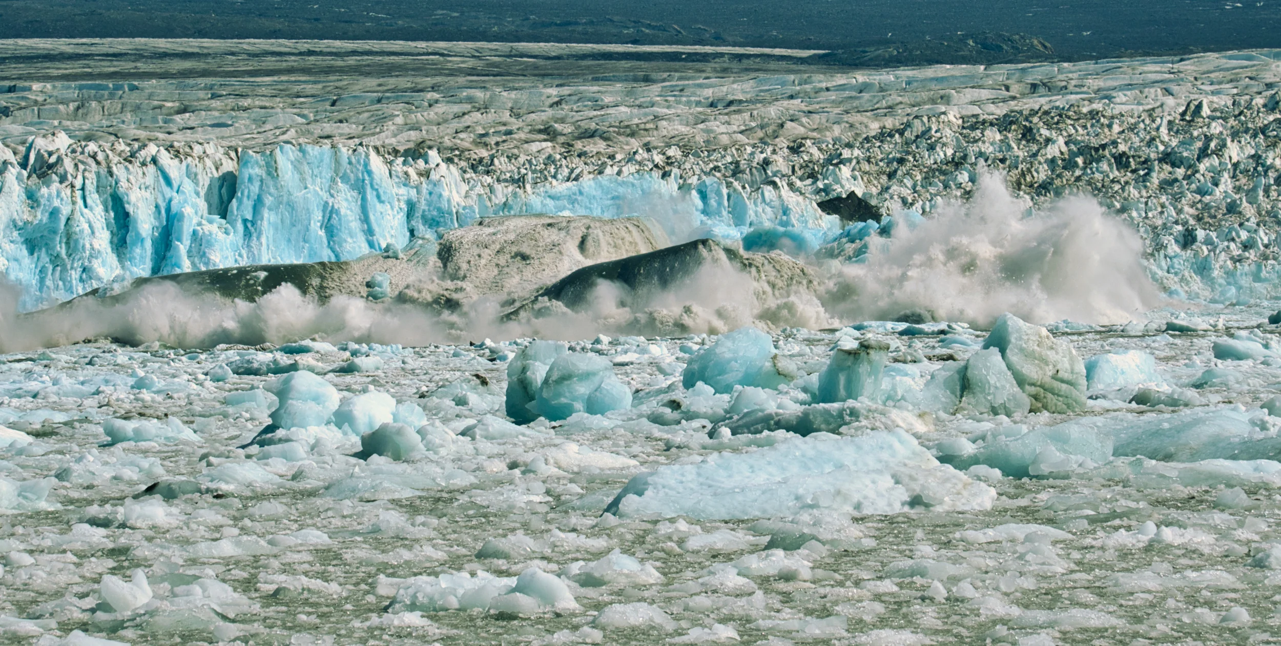 The blue vertical you see is about 200 feet high, the berg that broke off is upside down with a small portion of the black bottom showing.