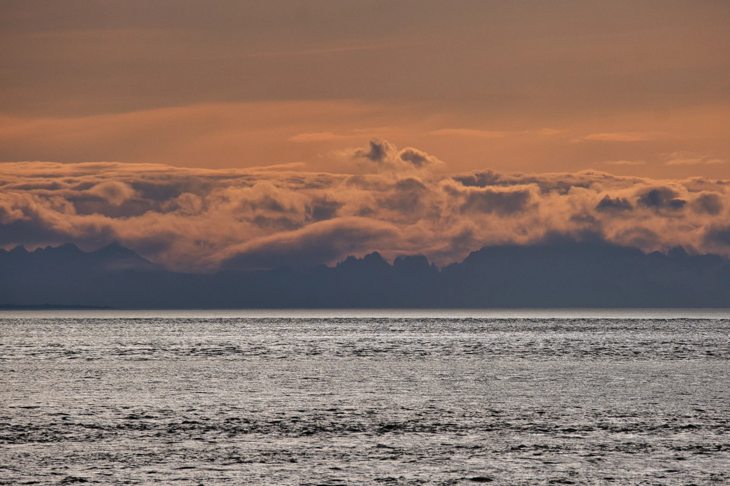 Cloud banks and faint mountains across Cook Inlet from Anchorage