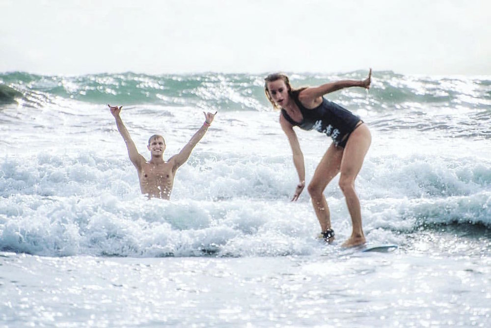 When he's not instructing on the bike in NYC, Manta leads Surf + Yoga retreats to remote destinations. Pictured far above in a weekend day trip to New York's Rockaway beach, and above, teaching SW to surf in Costa Rica. 