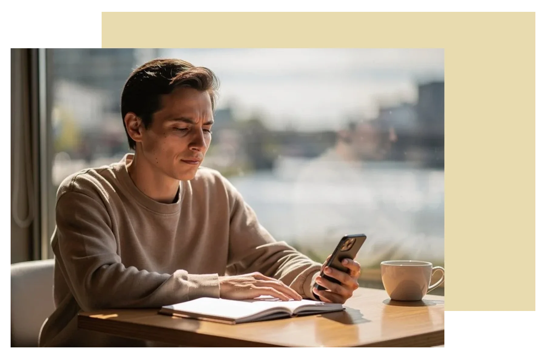 Man reading on his phone at a table, reaching out for online life transitions counselling in New Westminster