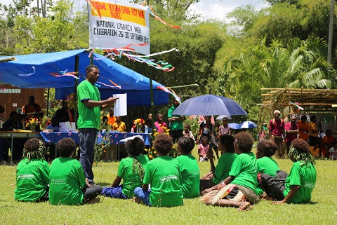 Adult literacy and numeracy students (above and below) perform activities at Zindaga Primary School grounds.