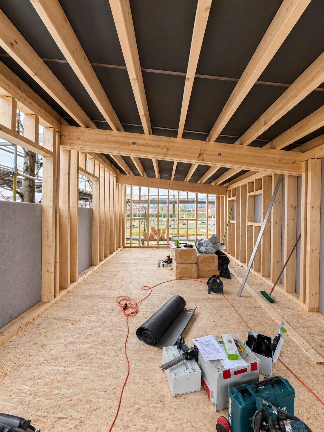 Holzrahmenbau im Rohbau mit Werkzeugen.png