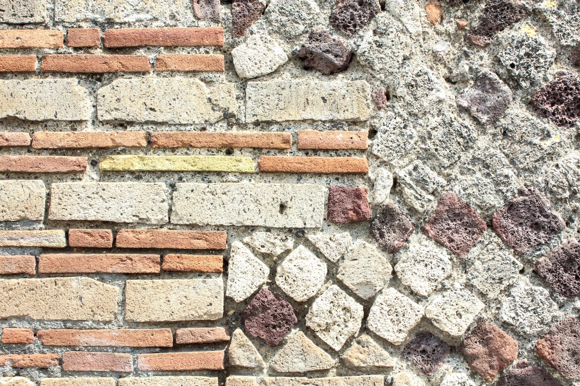 Close-up of a decorative stone and brick wall with various textures and colors.