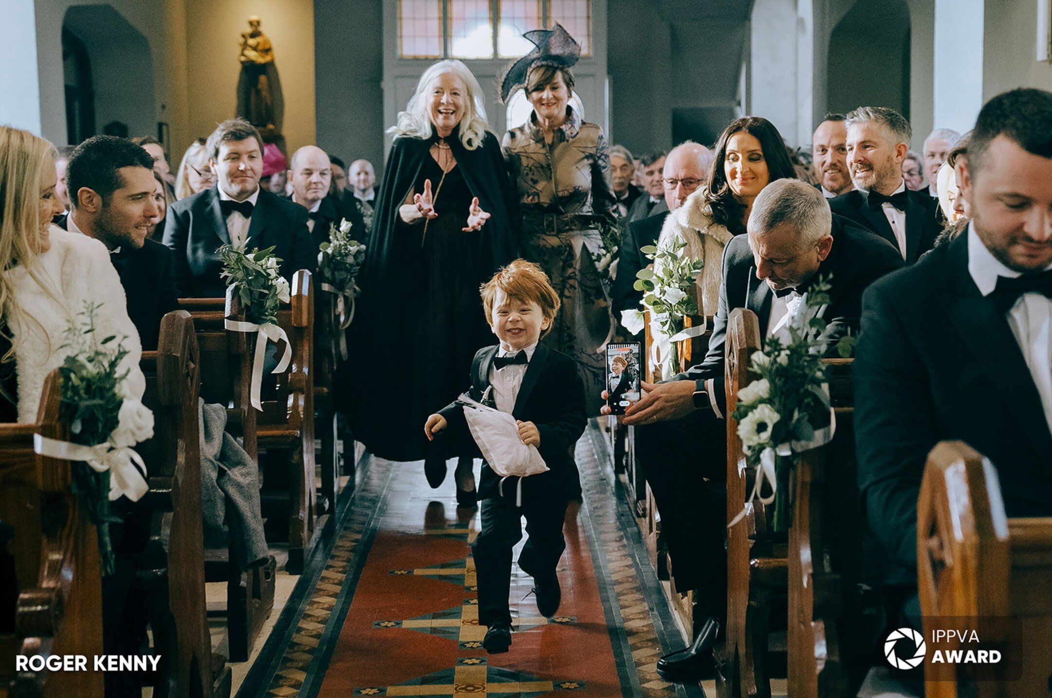 Love this shot of the ring bearer running up the aisle with his Grandmother's left behind! Another award winning photograph from the Winter Wedding Documentary Awards of the @i.p.p.v.a 
@kilshanehouse 

#banshachurch #portraitroom #ippav #kilshanehou