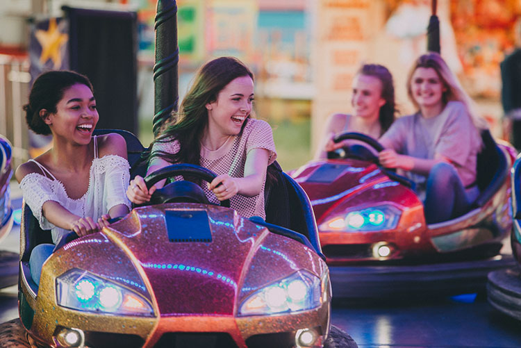 Laughing young girls playing bumper cars