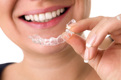 Woman holding Invisalign clear aligner