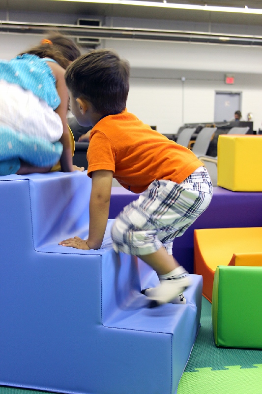 A child climbing on the soft block area at Play Away's indoor playground.