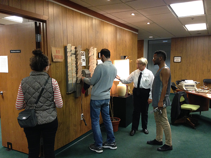 Officer Ann Maines instructs participants on punch clock etiquette. Photo by artist.