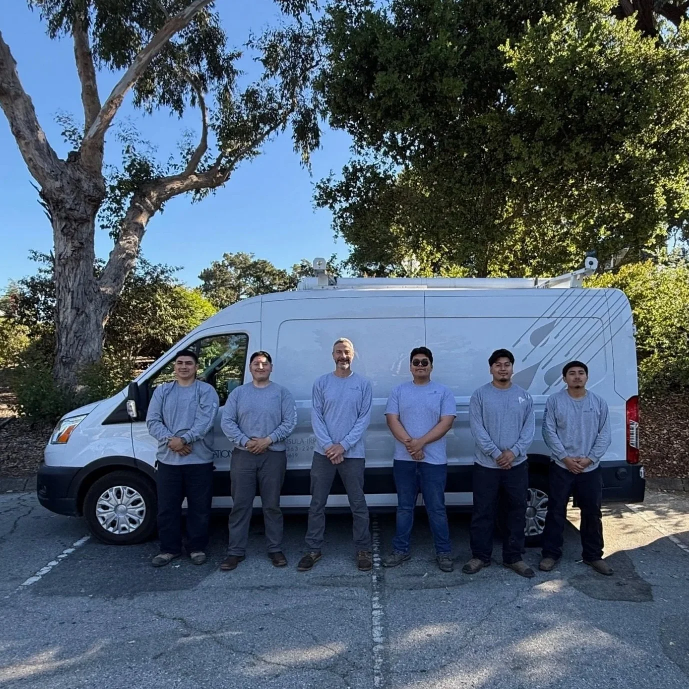 The Peninsula Irrigation crew of licensed plumbers stand in front of the company workvan.
