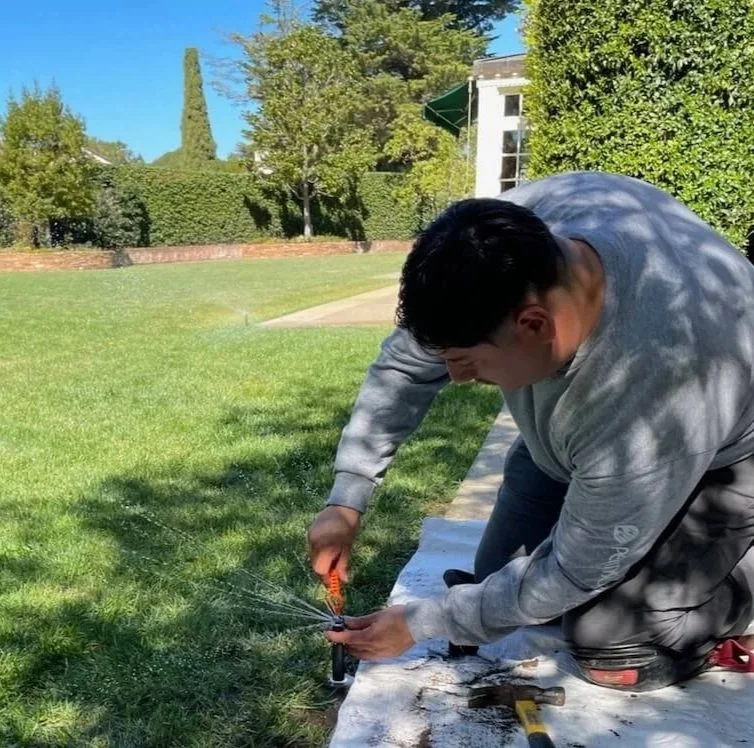 Licensed plumber who is an irrigation specialist repairs a broken sprinkler spigot.