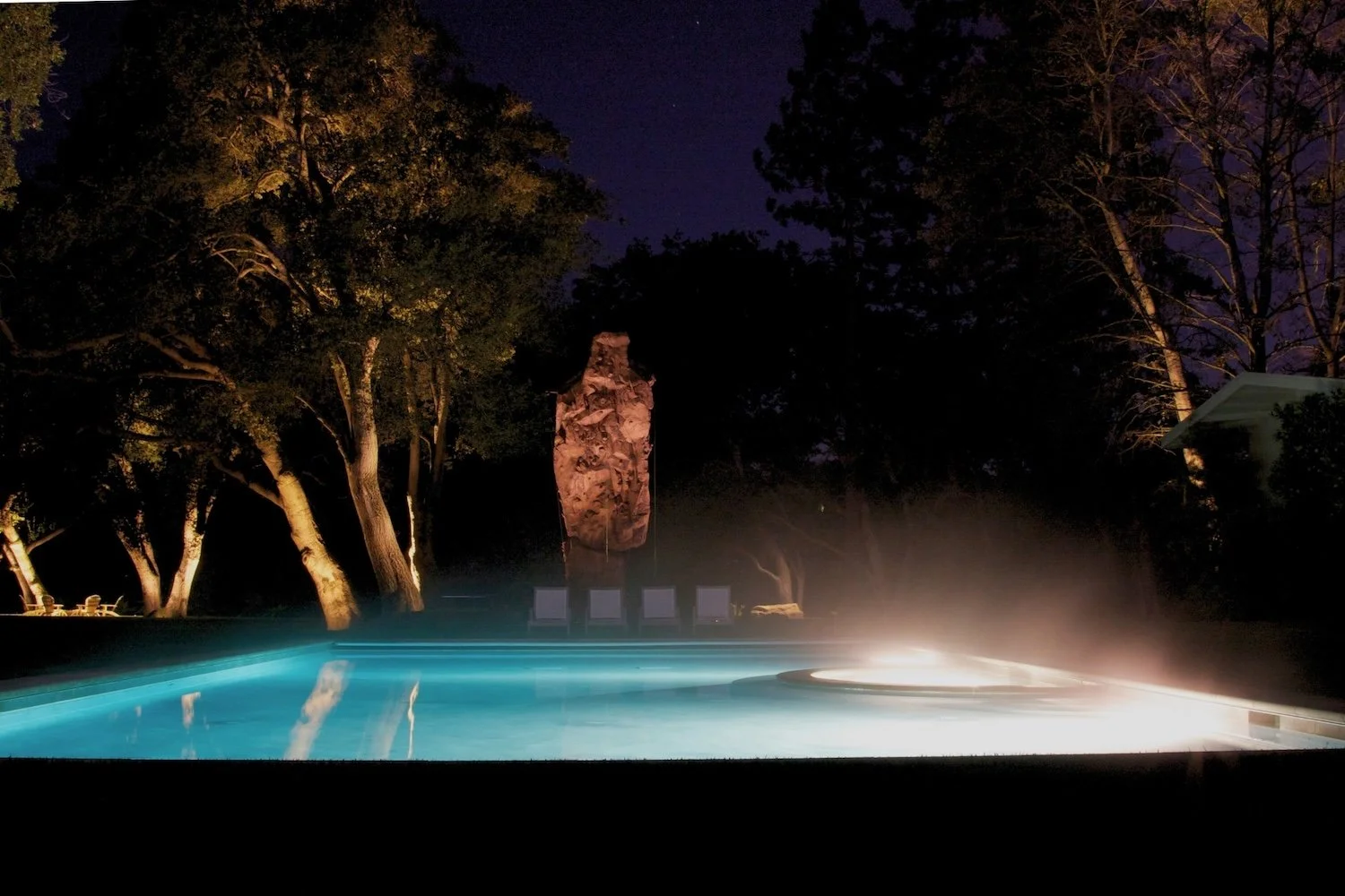 Custom landscape lighting in Foster City highlighting beautiful pool area and trees.
