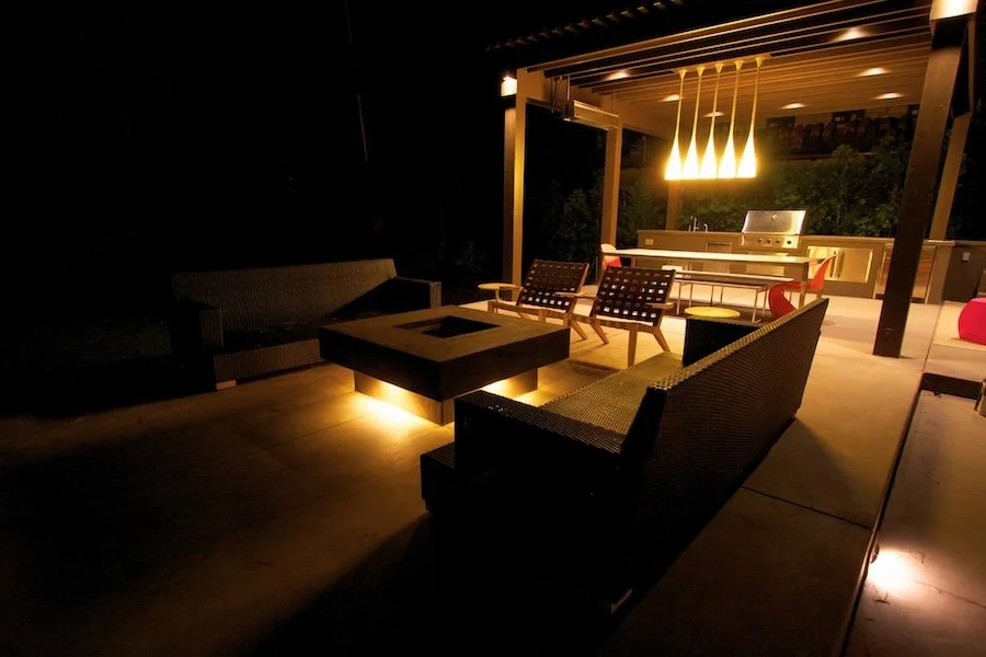 Exterior lighting for patio area installed in Redwood City, CA to showcase beautiful outdoor fire pit, seating, and barbecue area.