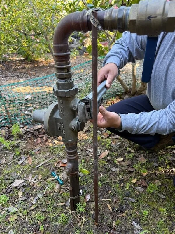 Licensed plumber adjusting water mainline pressure and flow to correct poor performance issues.