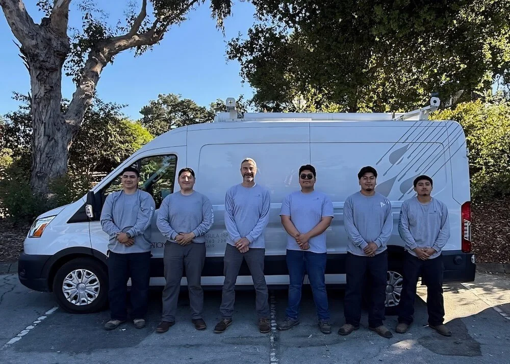 The licensed plumbers of Peninsula Irrigation Co. standing in front of the company work van.