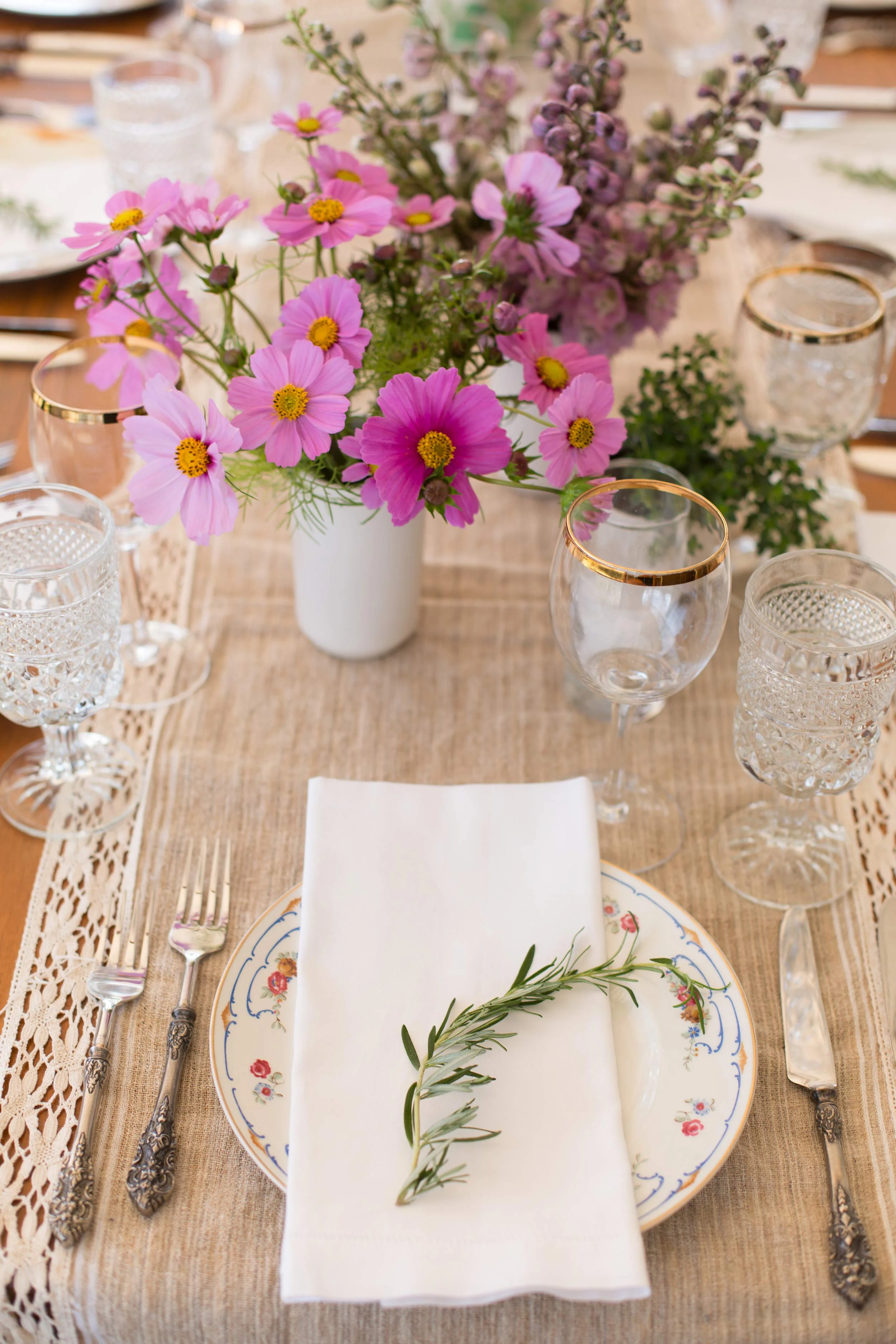 Bohemian table setting with wildflowers and rosemary with eclectic vintage plates at Spring Ranch Barn in Mendocino