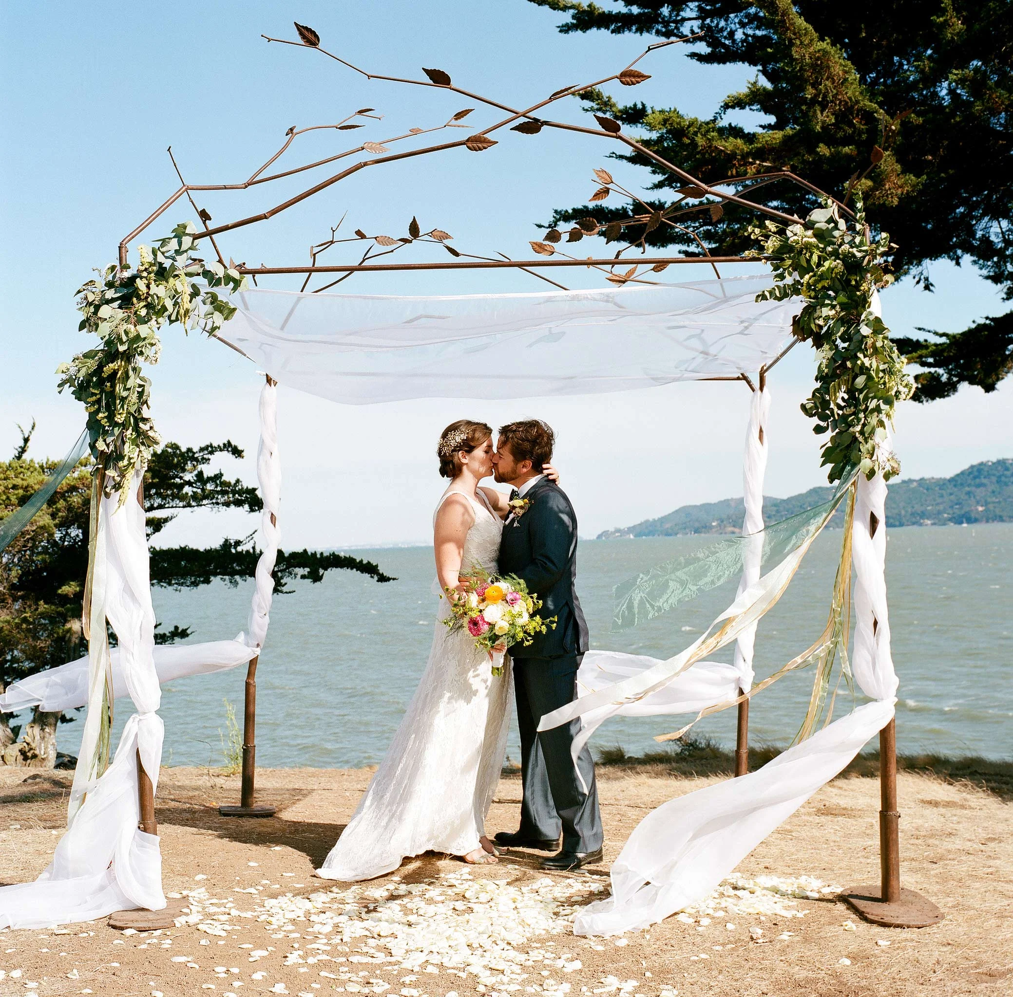 Bride and groom under outdoor chuppa in Marin bluff overlooking the San Francisco Bay