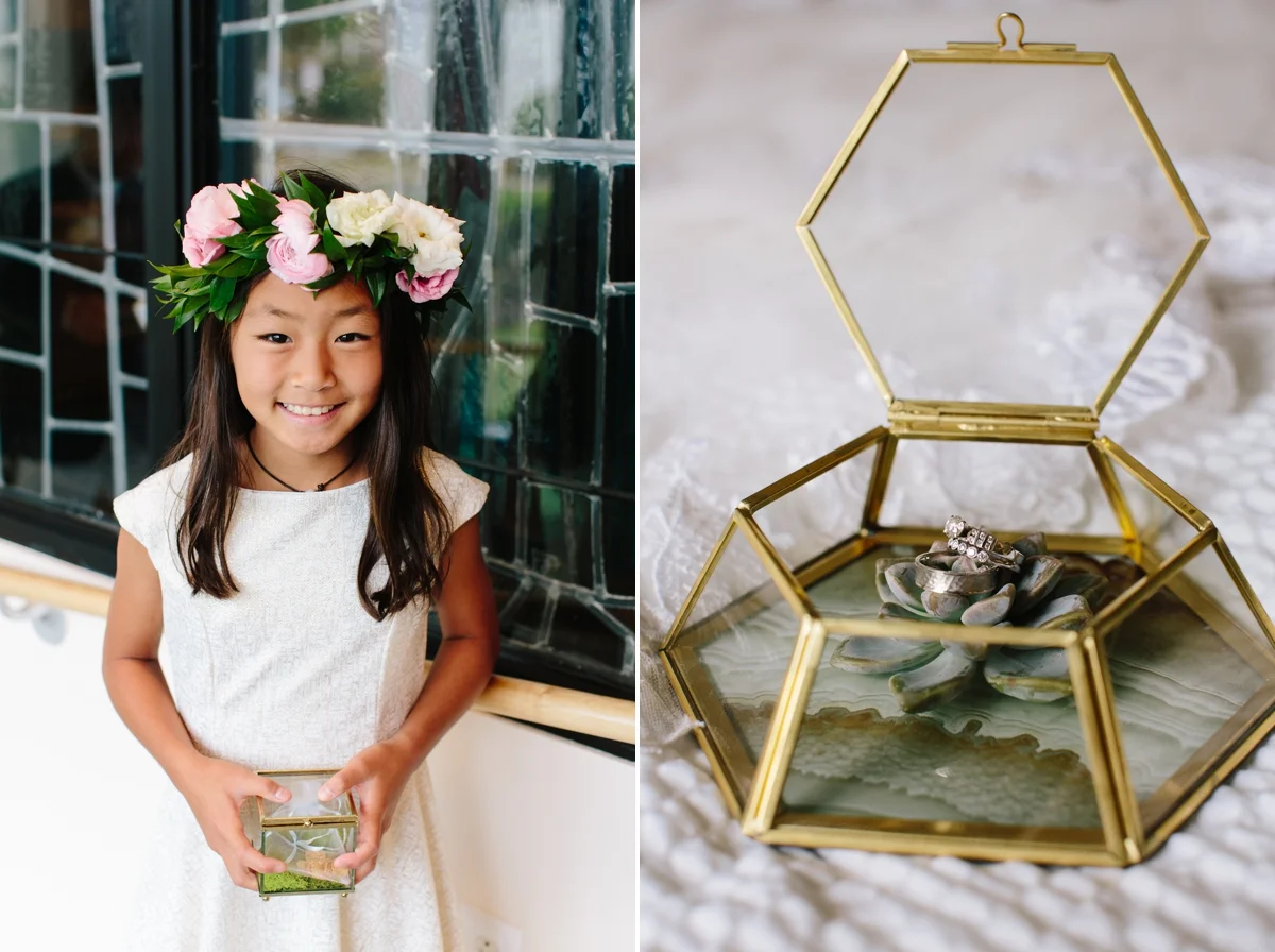 A smiling flower girl hold the glass ring box, while wearing a flower crown.