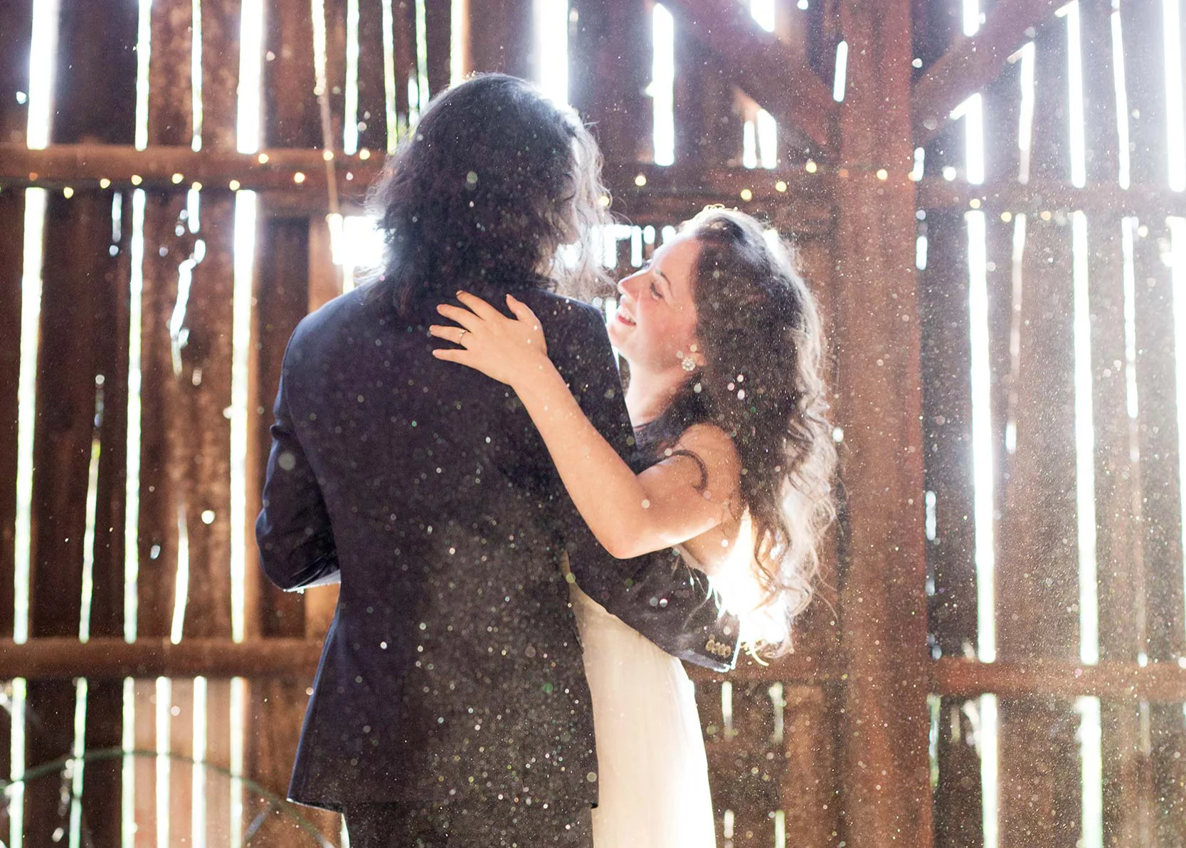 Bride and groom dancing in sunbeams in the barn during first dance at Squirrel Creek Ranch in Grass Valley.