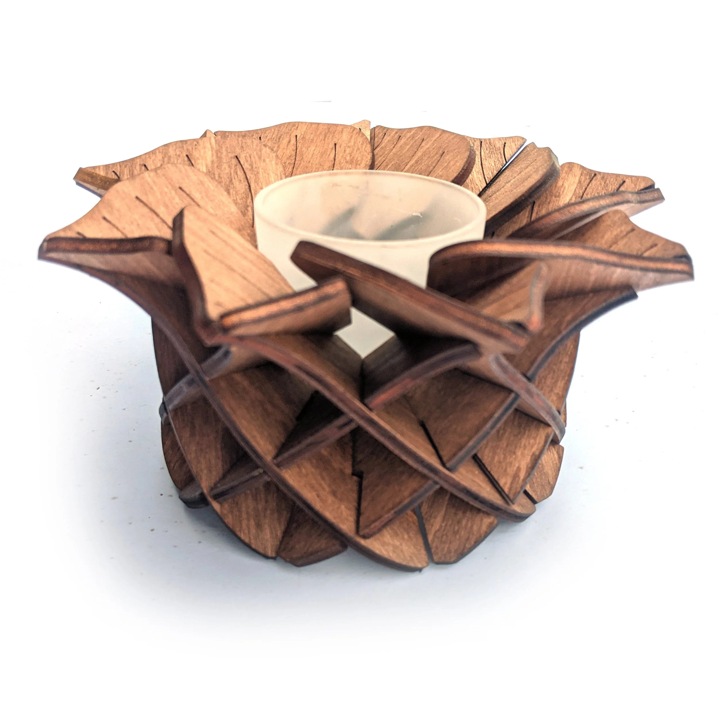NUXA acorn shaped wooden tealight holder handcrafted from interlocking oak lattice layers glowing with warm candle light.