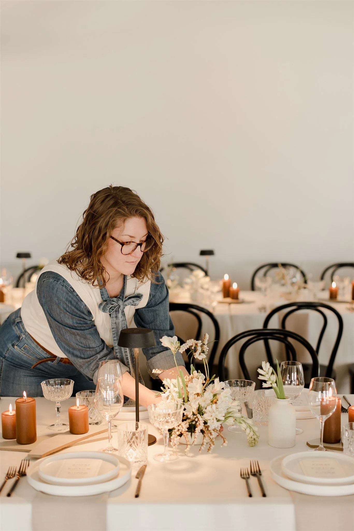 Caucasian Florist Adjusting Floral Centrepieces on a Wedding Table