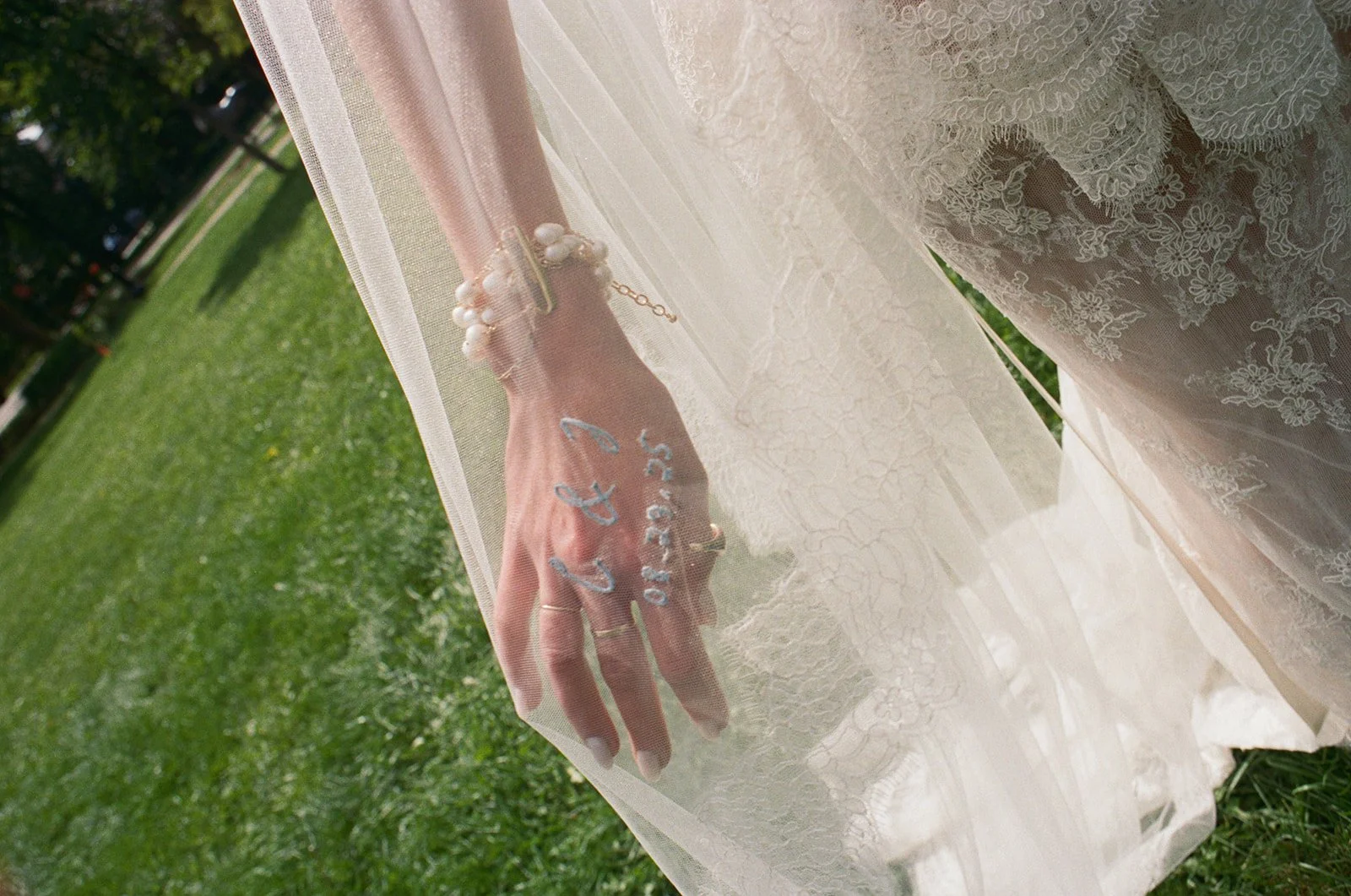 Bride's hand showing custom embroidery on her wedding gown