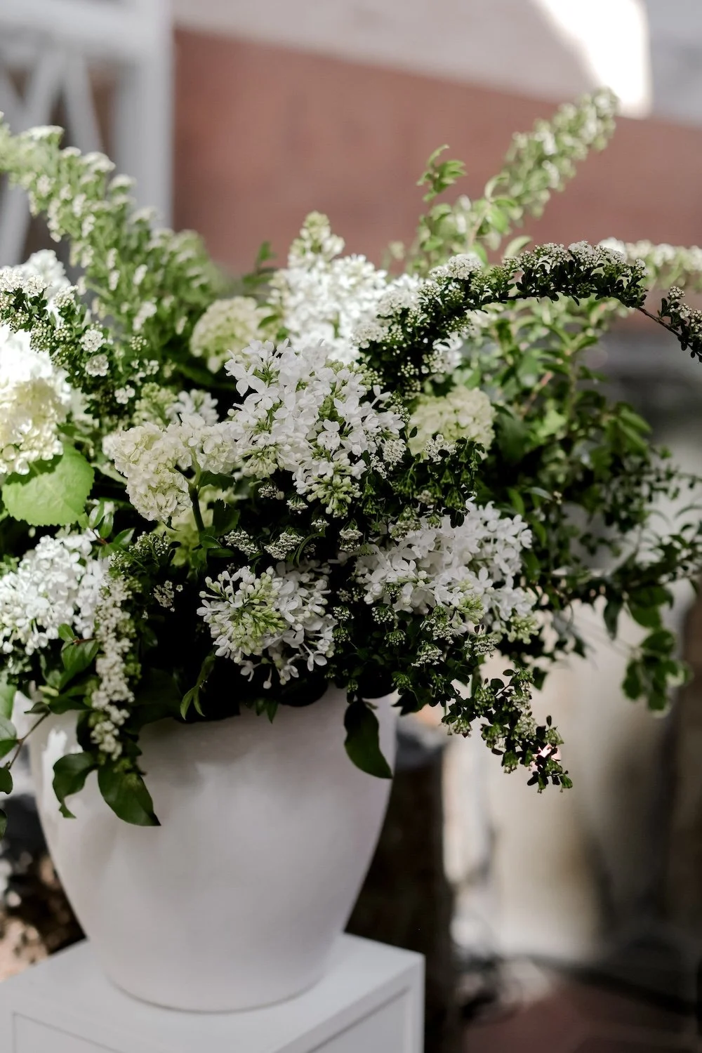 Large floral arrangement of flowering white spirea branches and white lilac