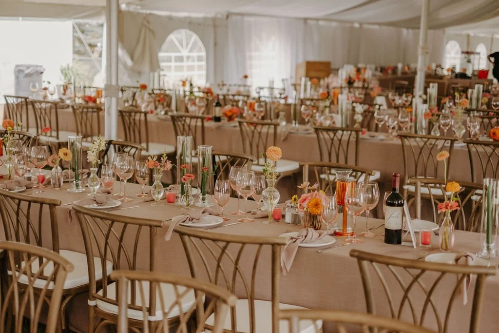 Tent Wedding Reception with Long Tables with colourful bud vases and flowers