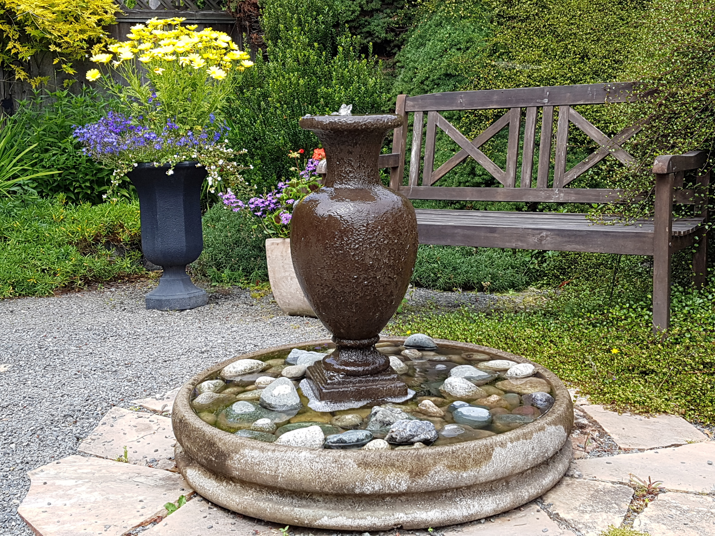 The combination of bench and urn fountain invites quiet contemplation.