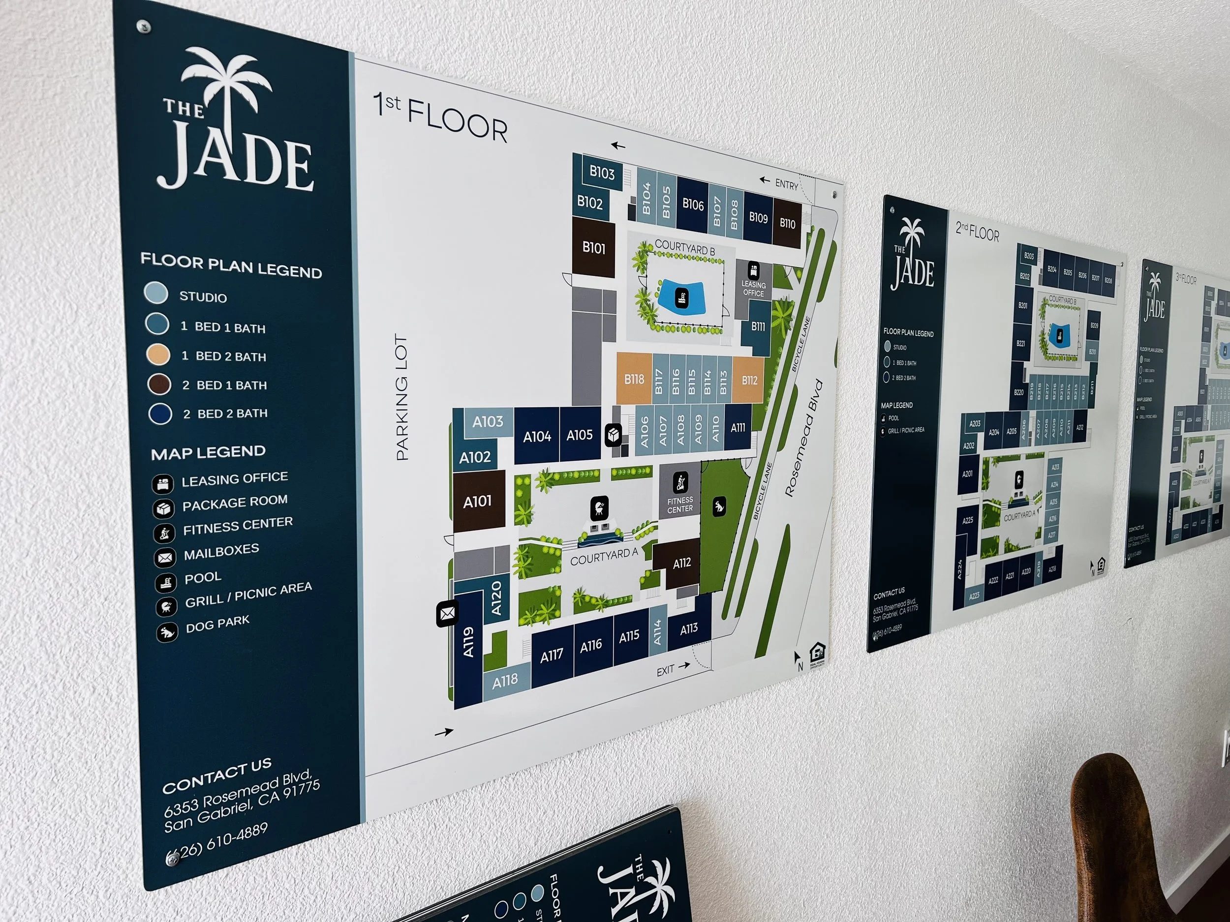 Aluminum signs mounted on a wall showing map legend of a apartment building