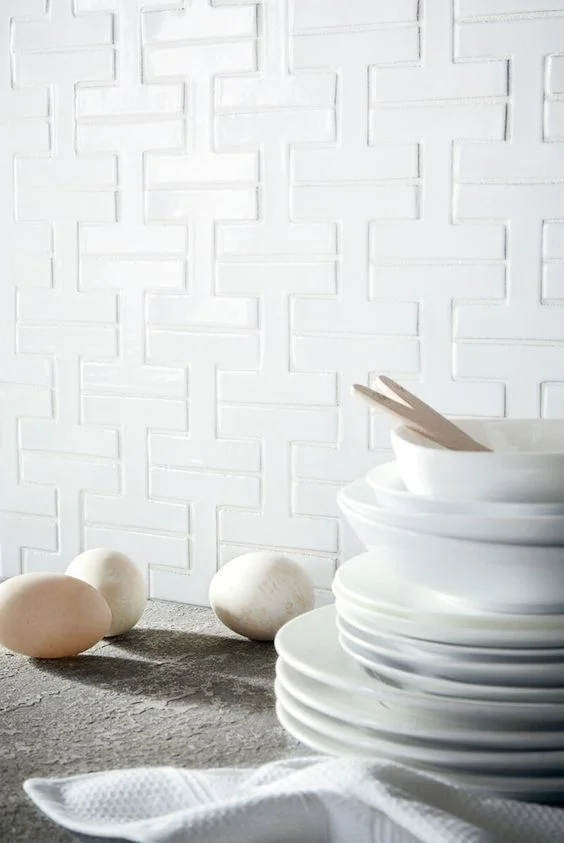 Interlocking “H” shaped geometric tiles called Chaine Homme, by Fireclay Tile . It has a mid-century modern appeal.