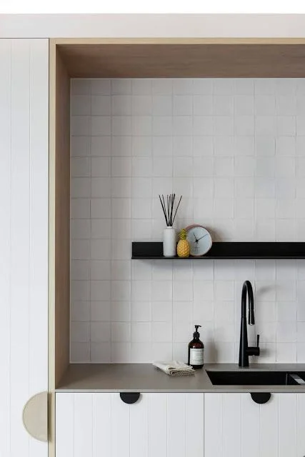 Handmade white butcher tiles in a simple grid pattern, cover many surfaces in this spectacular kitchen. Designed by: Minosa