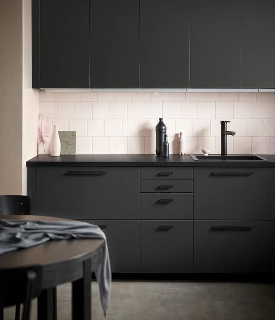 Soft pink tiled splashback with black Ikea kitchen. Here’s an interesting side note, the cabinets are made from recycled plastic bottles. Industrial Design: Form Us With Love