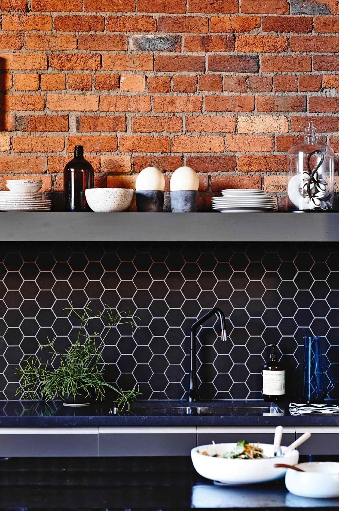 Industrial style kitchen with dark, dramatic tiles. Clever use of white grout to accent the honeycomb pattern. Styled by: Rachel Vigor