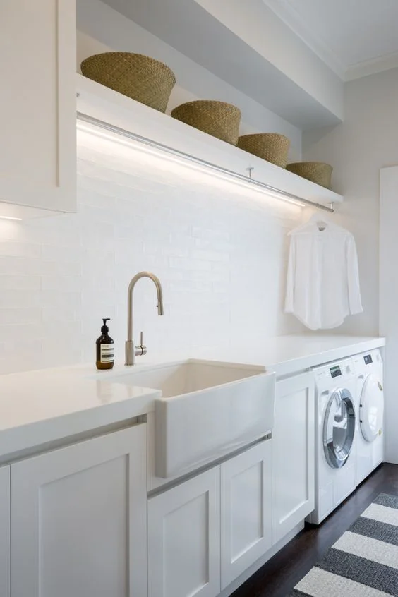A fresh, Hamptons style laundry with ample hanging space. Notice the clever strip lighting above. | Janey Larsen Design