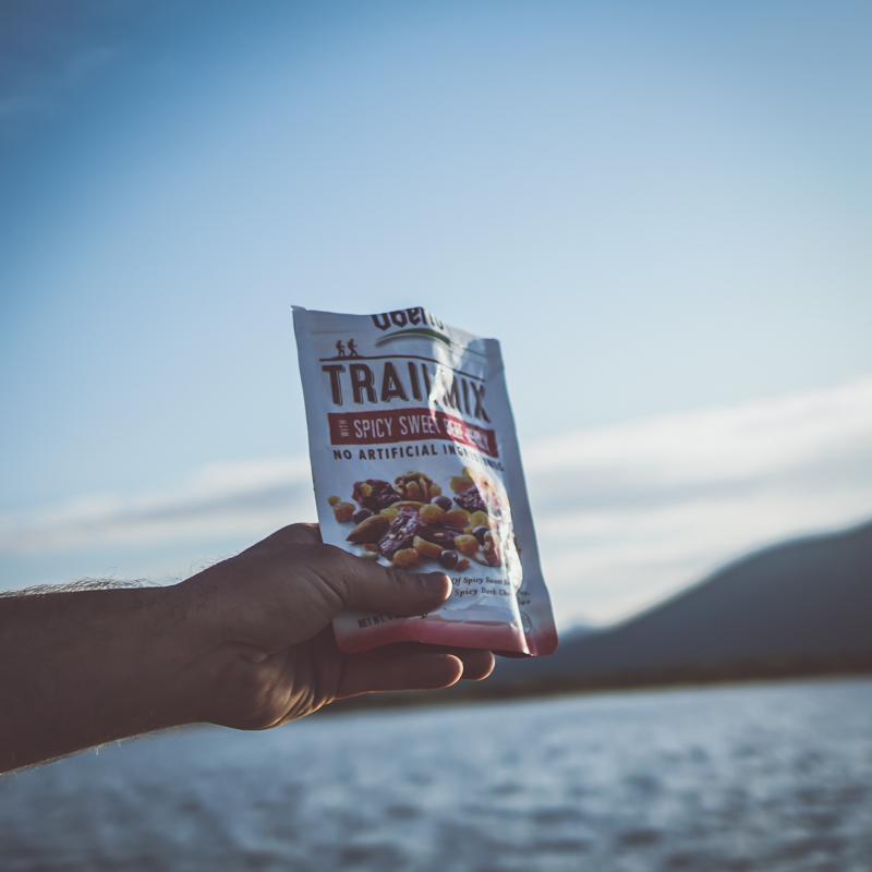 Trail Mix with Jerky held out on a mountain lake