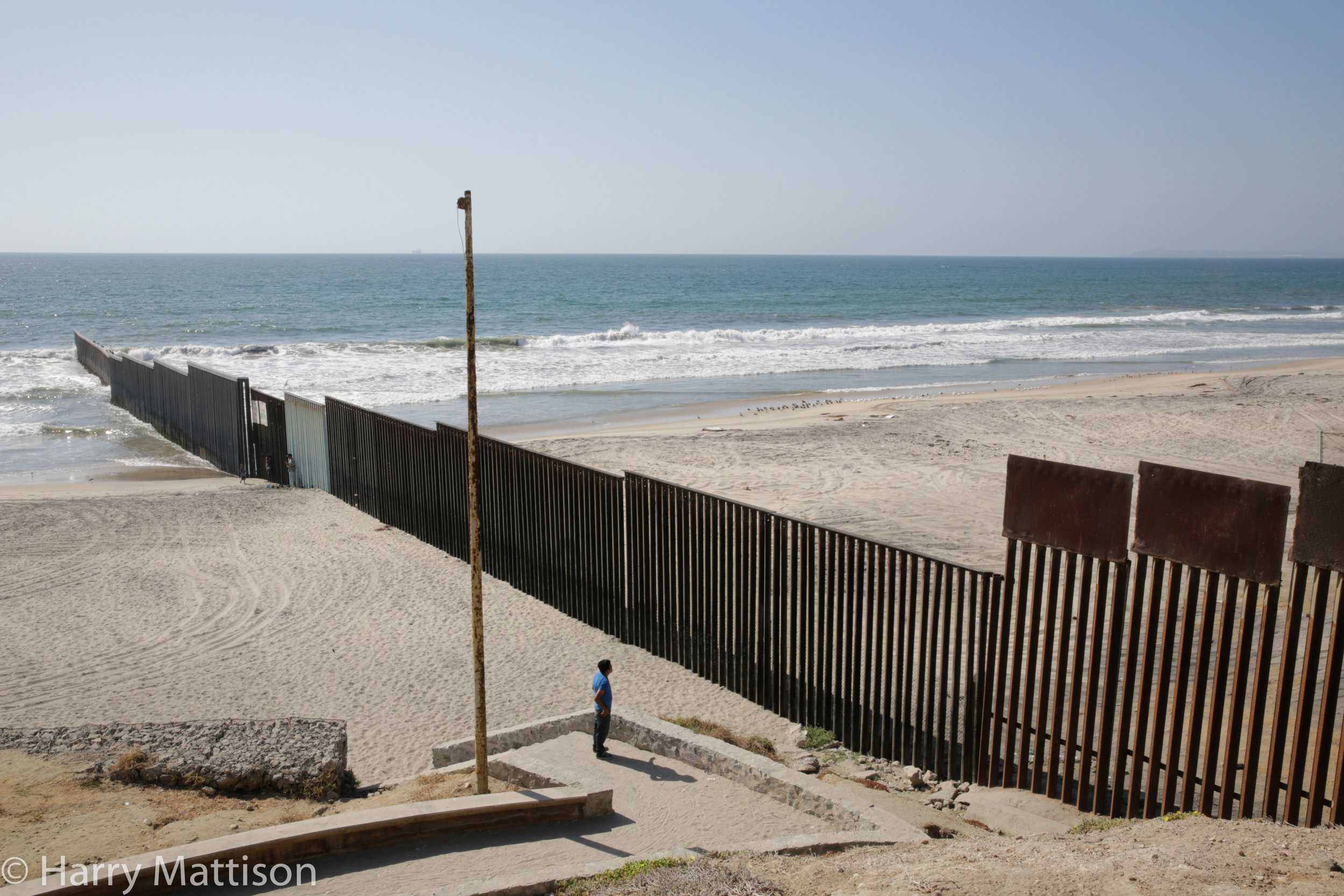  A man looking at the border fence from Playas de Tijuana towards the United States. 