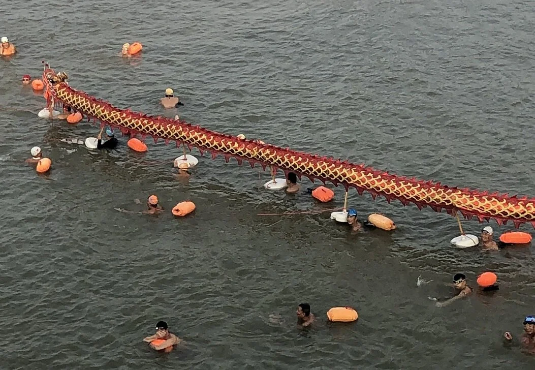 A local swim club parading a dragon down the Yangtze River. They enjoy passing by cruise ships.