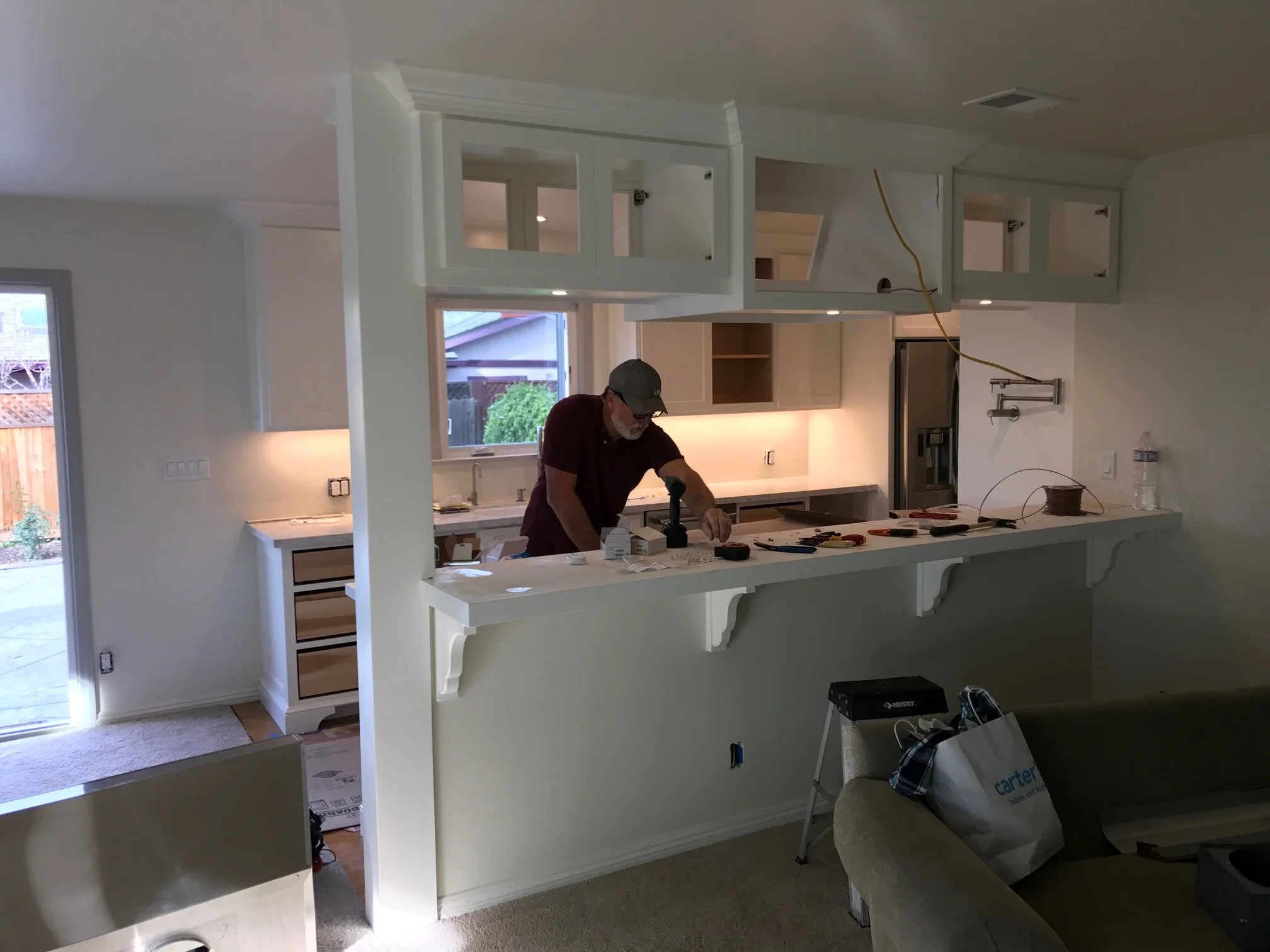  2/15. &nbsp;John is prepping to install the hood vent. &nbsp;You can now see the under-cabinet lighting our electrician put in this morning, which looks great. 