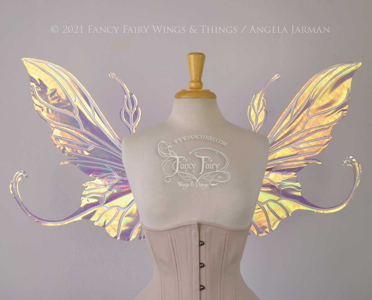  Front view of an ivory dress form wearing an alabaster underbust corset &amp; large pinkish iridescent fairy wings with elongated upper panels &amp; antennae with bottom panels that have a tail curving upwards, white veins 