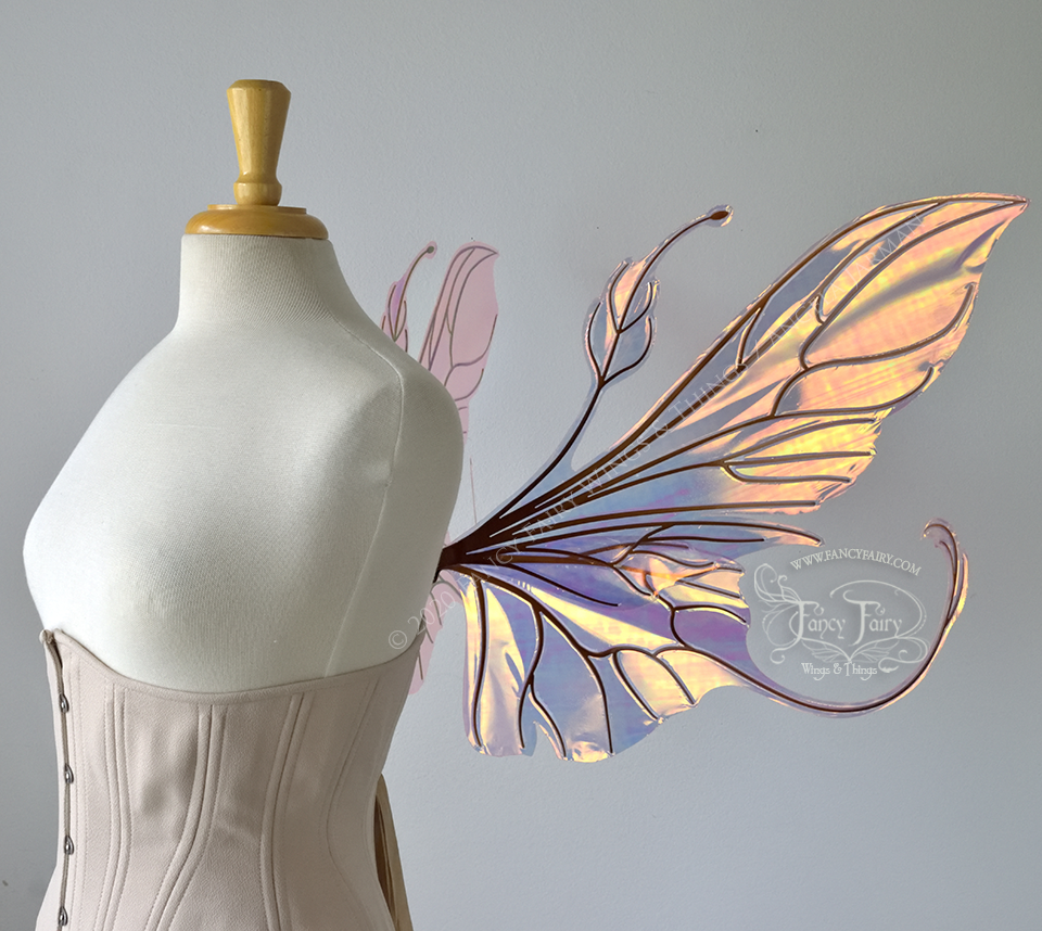  Right side view of an ivory dress form wearing an alabaster underbust corset &amp; large neon pink iridescent fairy wings with elongated upper panels &amp; antennae with bottom panels that have a tail curving upwards, copper veins 