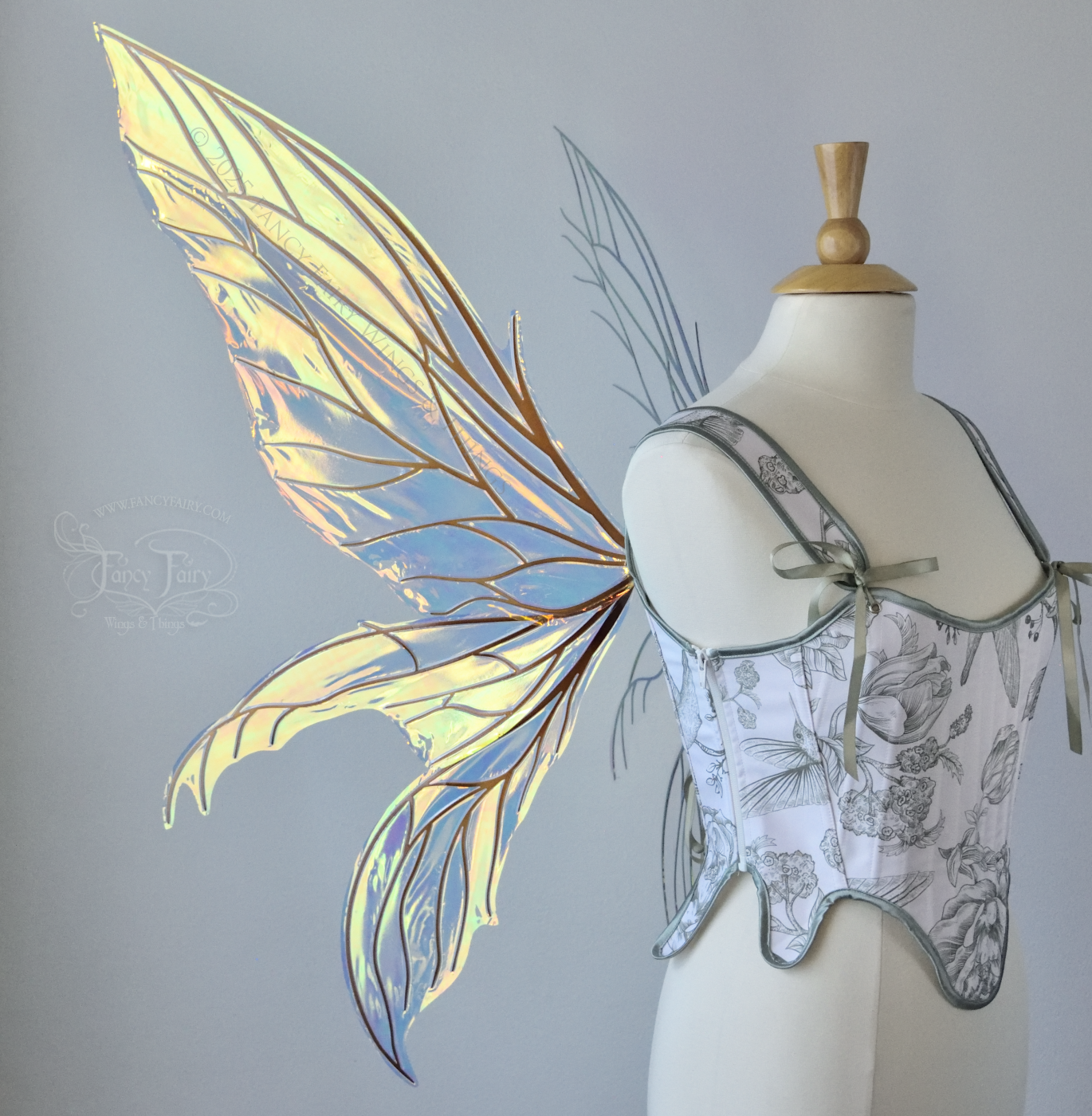  Large transparent iridescent orange/yellow/green dragonfly-like iridescent fairy wings with copper veins have 3 elongated panels on each side, worn on a dress form, left side view 