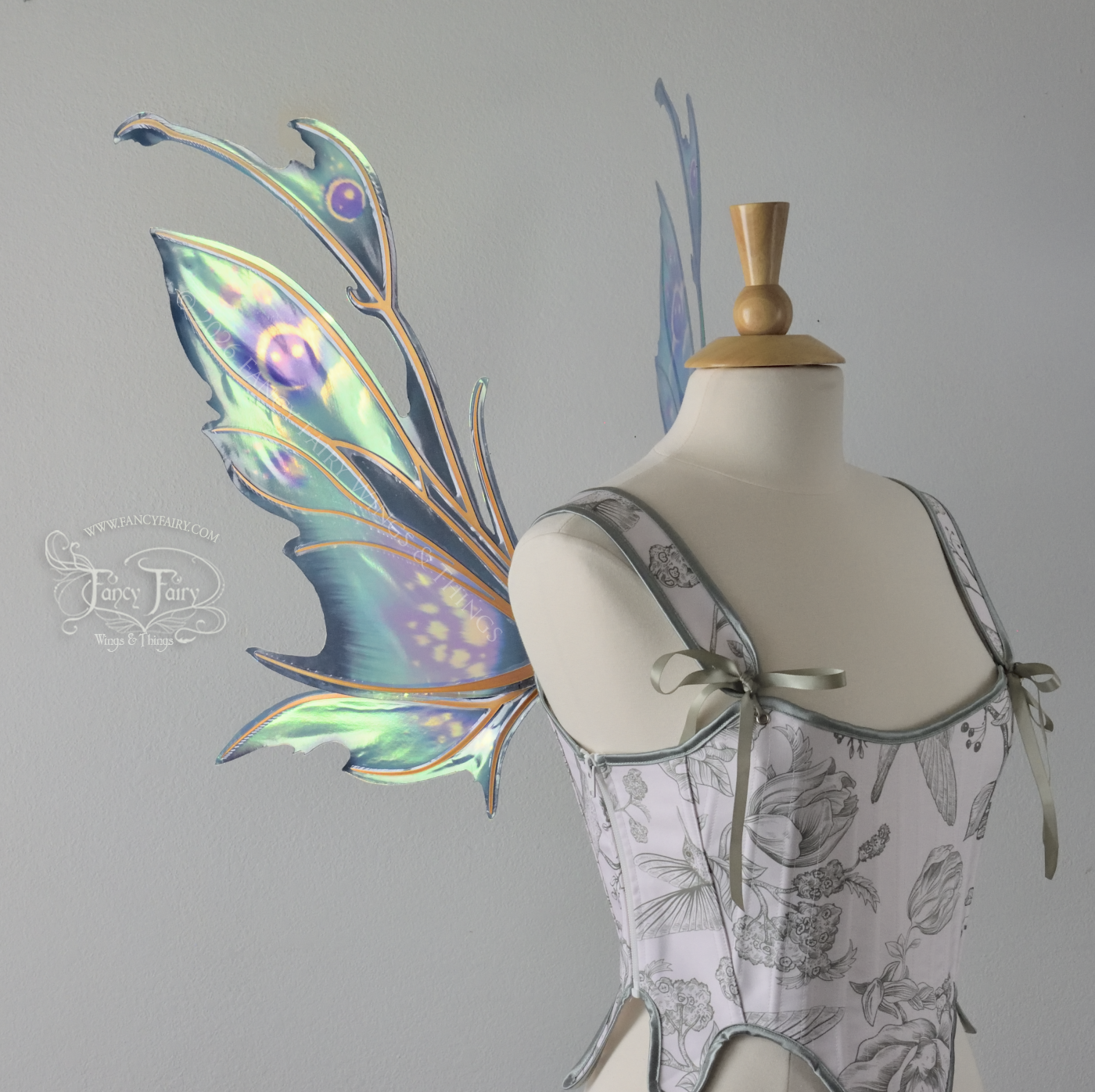  Iridescent fairy wings with a spikey profile &amp; antennae worn on a dress form, painted in shades of teal and purple, left side view 