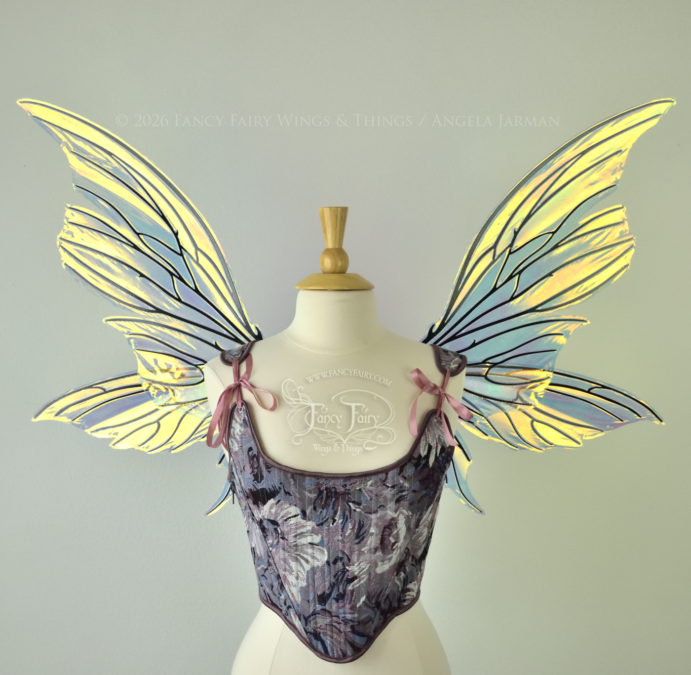 Iridescent yellow/orange/green transparent fairy wings with lots of 'thorny' black veins, worn on a dress form, front view