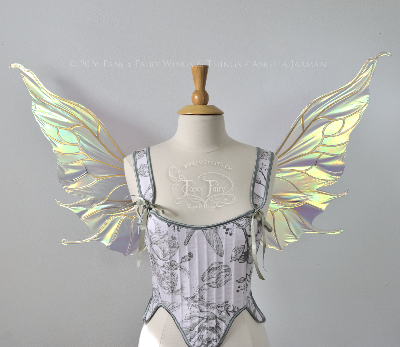 Sheer green iridescent fairy wings with wavy tips and gold veins, worn on a dress form, front view