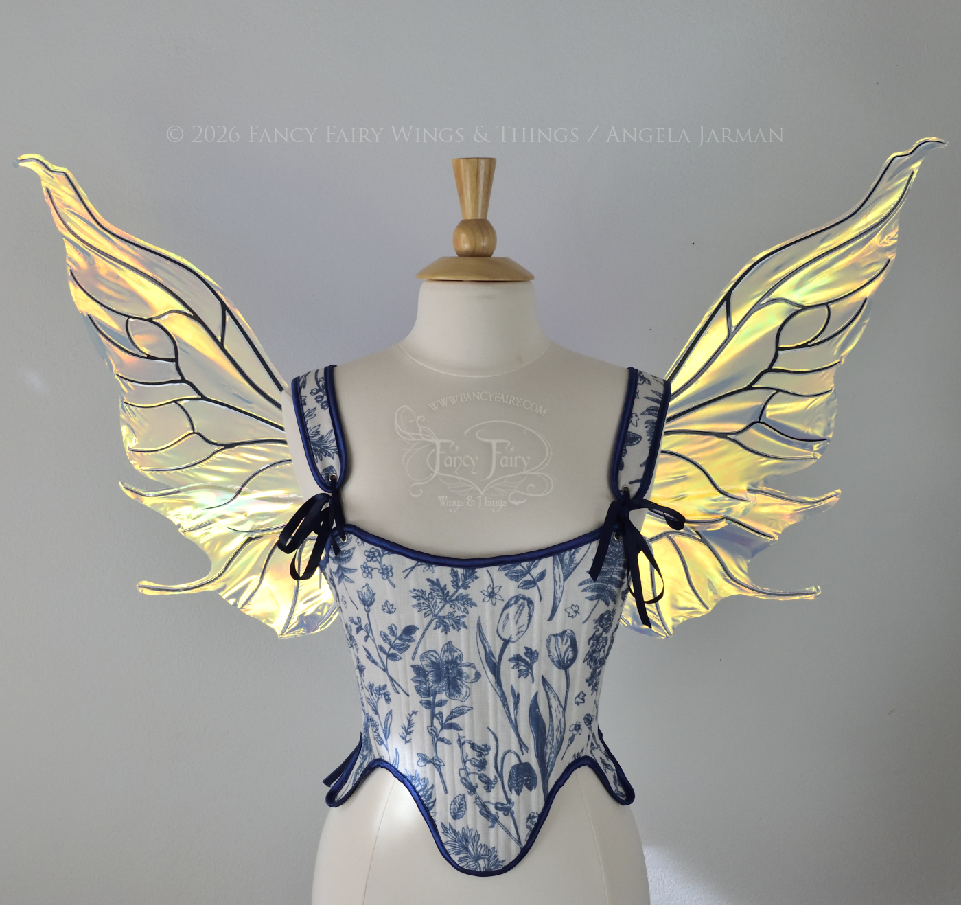 Transparent iridescent fairy wings with wavy tips and black veins, worn on a dress form, front view