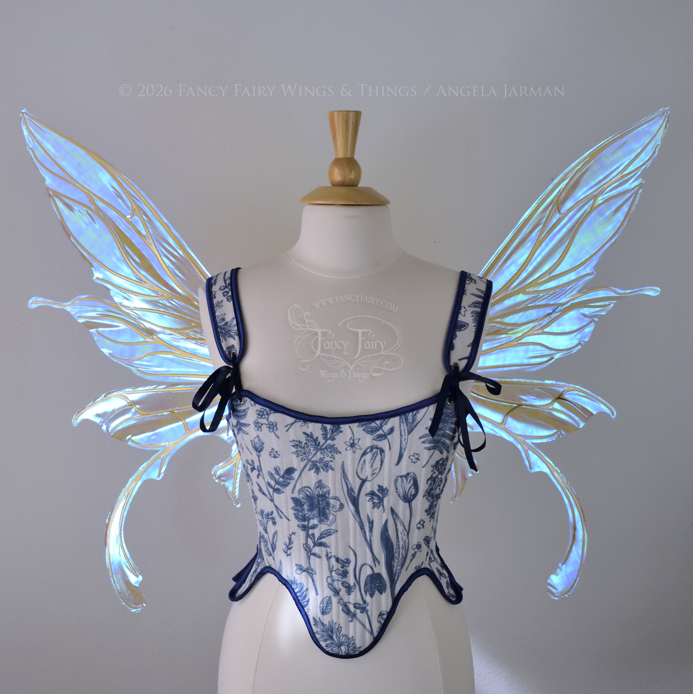 Transparent iridescent blue fairy wings with gold veins, 3 panels on each side, bottom panels have tails that curve inward at the bottom. Worn on a dress form, front view